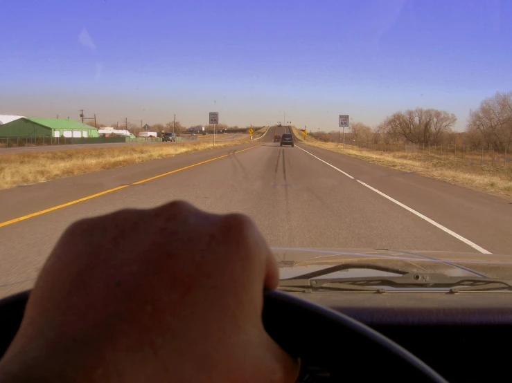 a person driving down the highway behind a vehicle