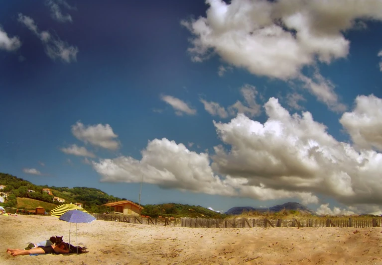 a sandy beach has an umbrella and some sand