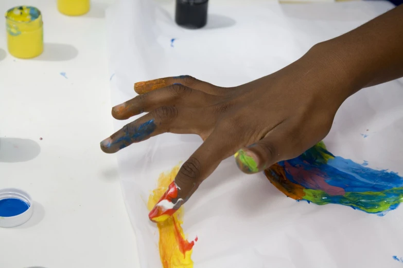 a young child playing with colored paint in a table