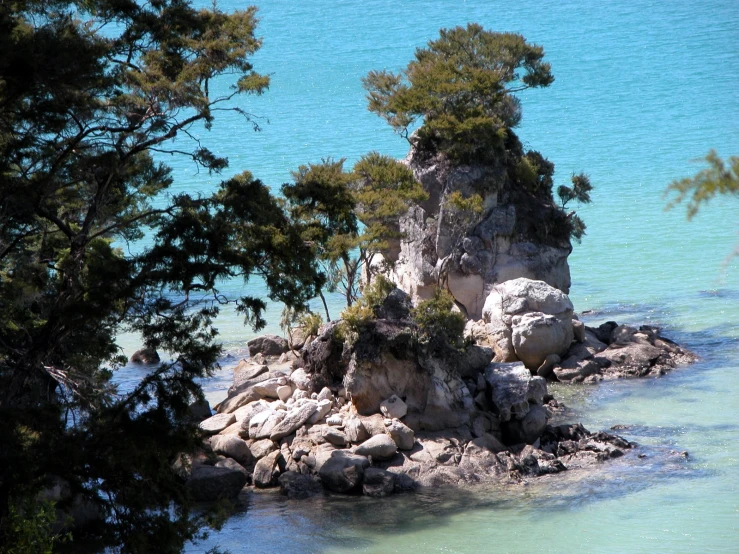 a very large rock out in the middle of a body of water