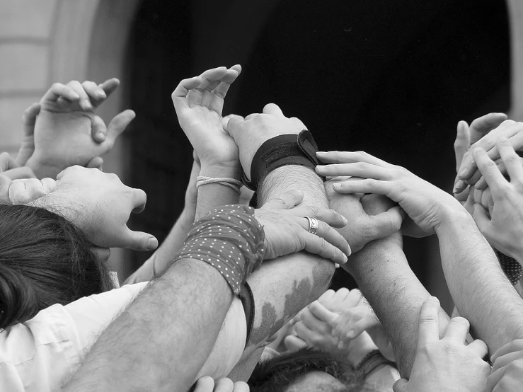 a group of people making a pile of hands up in the air