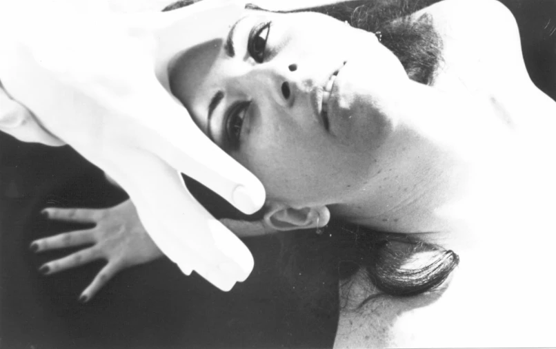 a woman lying down with her hands on her face