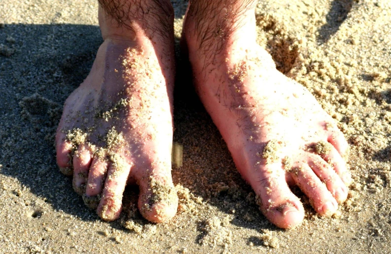 someone standing in the sand with his feet covered by sand