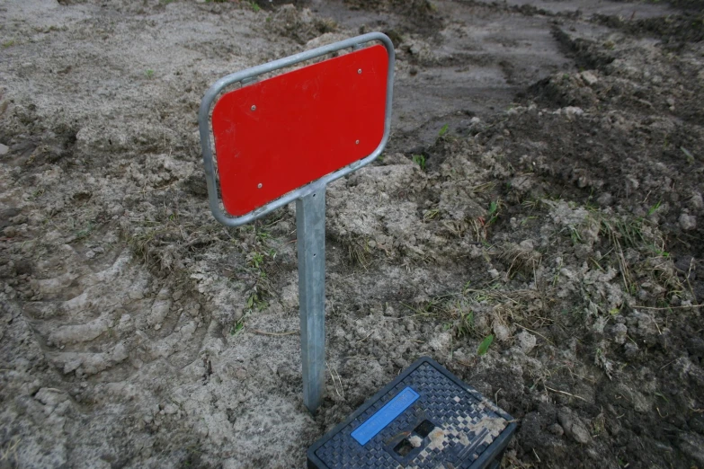 a red sign next to a blue object on the ground