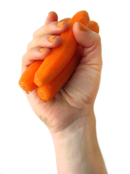 a person holding up some carrots to show their orange 