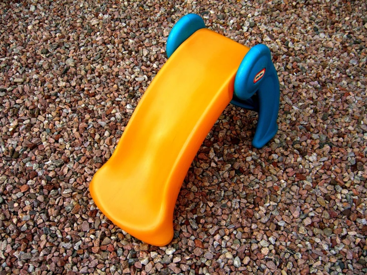 a playground slide and some gravel on the ground