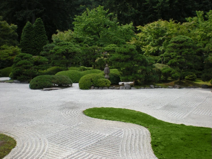 the white graveled path is lined with trees and grass