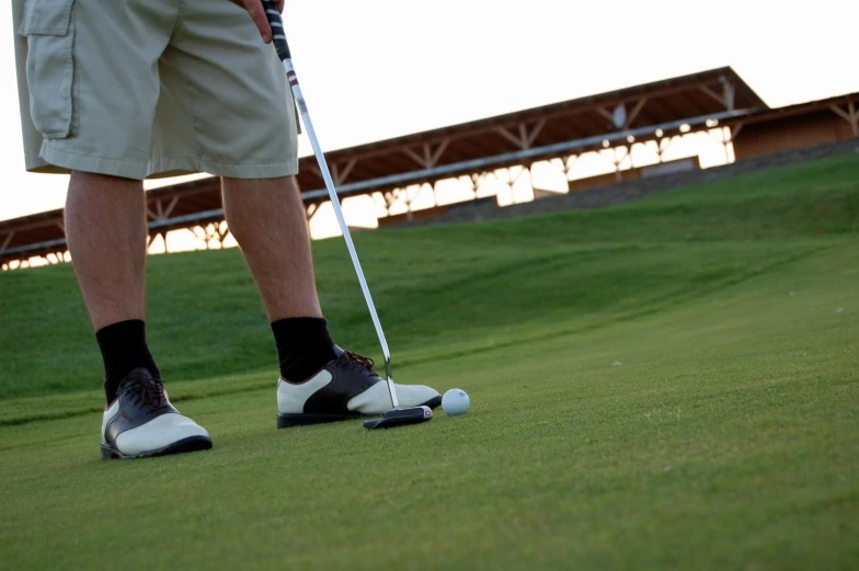 someone standing on the green with a baseball bat