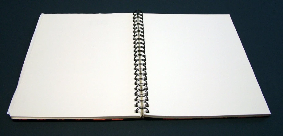 a white notebook sits open on a table