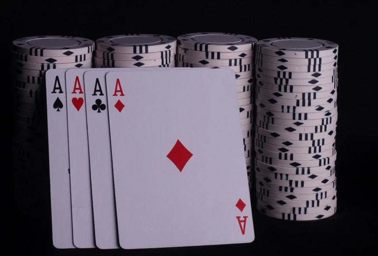 four sets of playing cards with two stacks of poker chips nearby