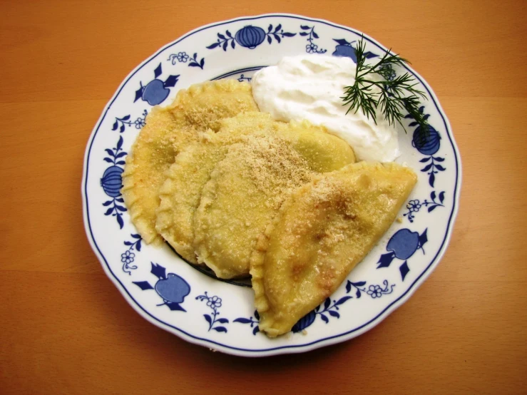 a piece of pie with sour cream sits on a blue and white plate