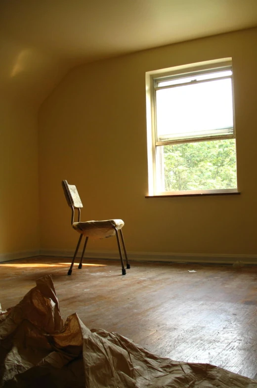 an empty room with an open window and a curtain