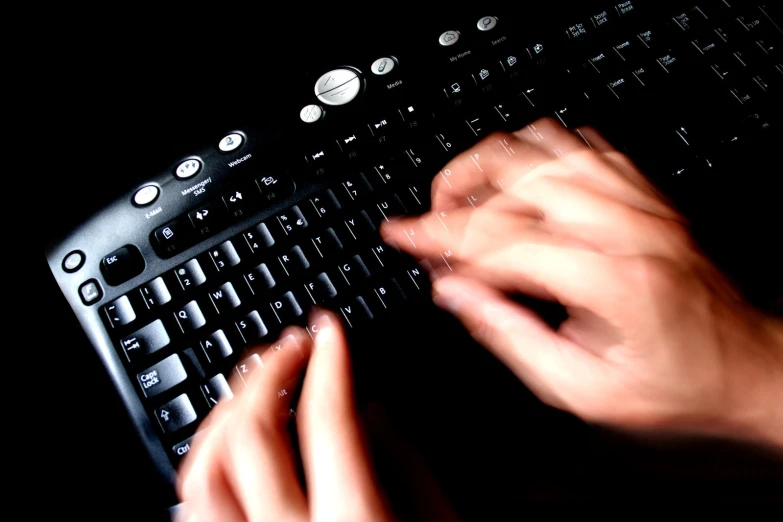 a person is typing on a keyboard using their hands