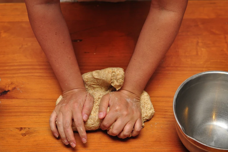 a woman using a bread roll to knead the dough