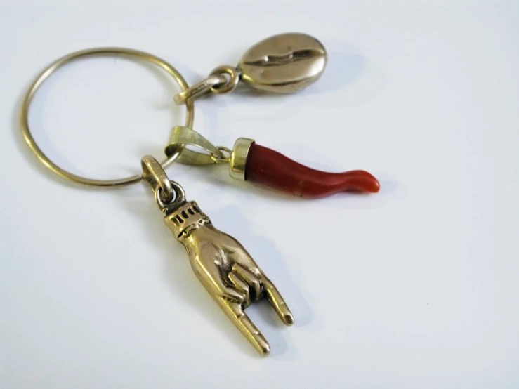 a metal key chain with two red pieces