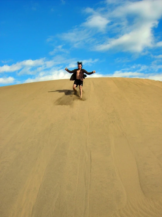 a person on a steep hill with his arms outstretched