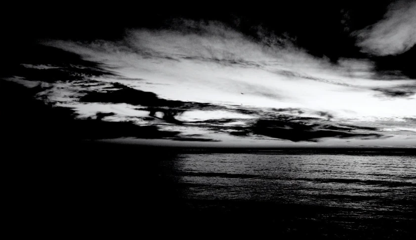 an open expanse of water under a cloudy sky