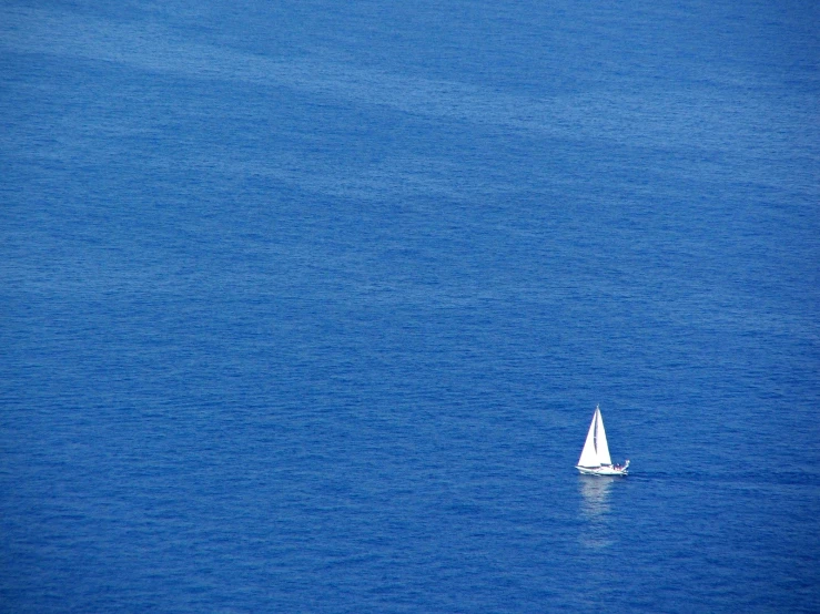 there is a small sailboat floating on the water
