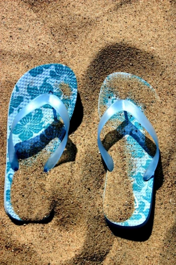 pair of sandals on beach with blue flower print