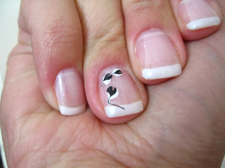 a woman holding onto her fingers with nail art on them