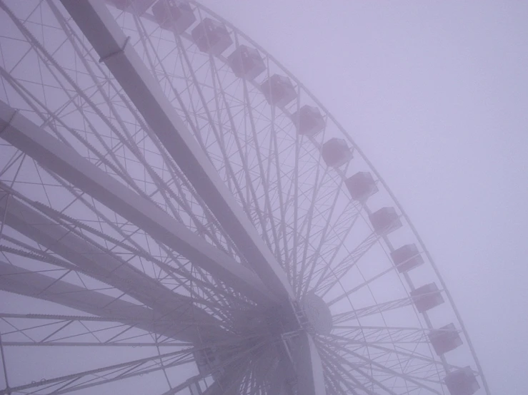 a large ferris wheel on a foggy day