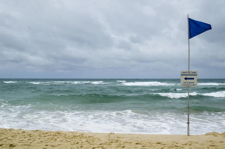 a beach with the ocean and sky in the background