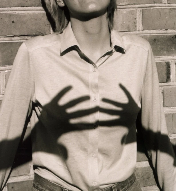 black and white po of a woman casting shadows on her shirt