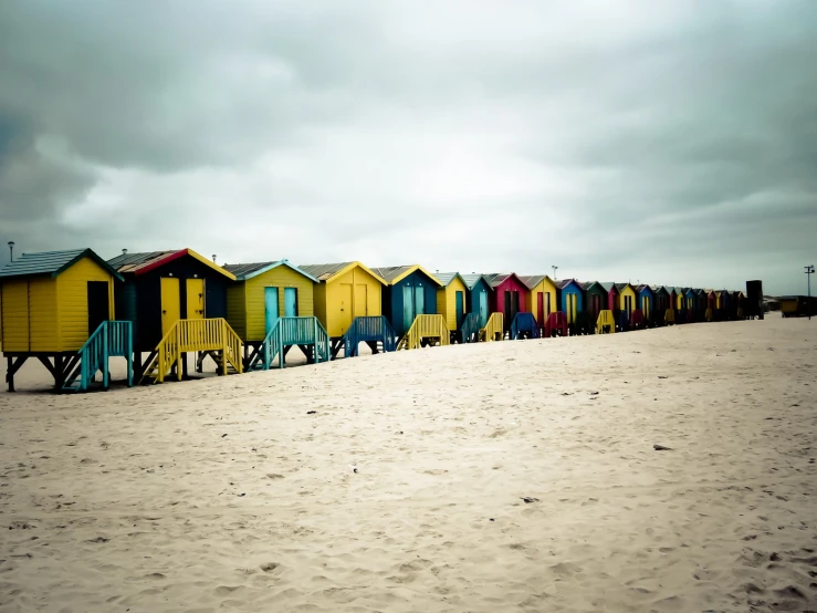 an area of sand with small, colorful huts on it