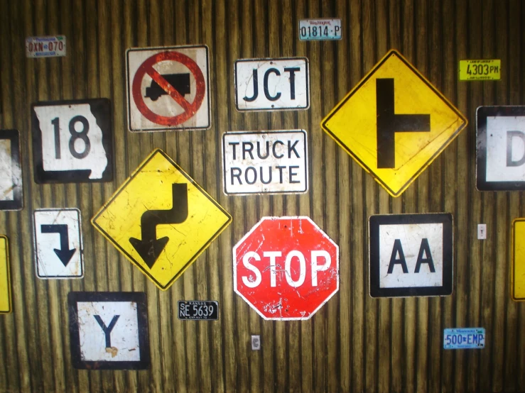 various road signs hanging on the wall next to each other
