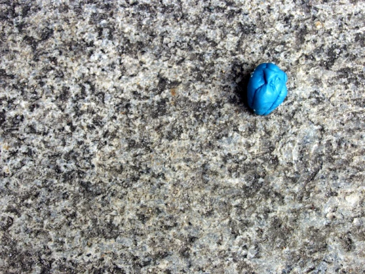 a blue rock is on some black ground