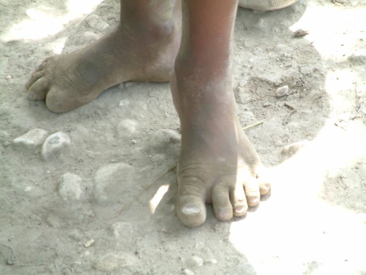 the dirt is covered with little mud while someone has their foot covered in sand