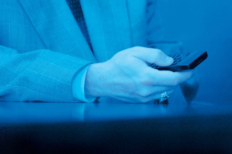 a man in a business suit operating his cell phone