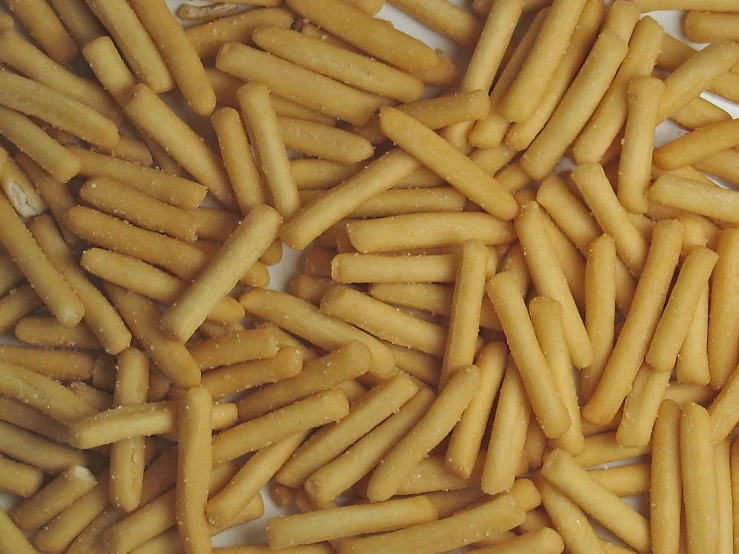 a pile of long shaped cookies that looks like they are fried