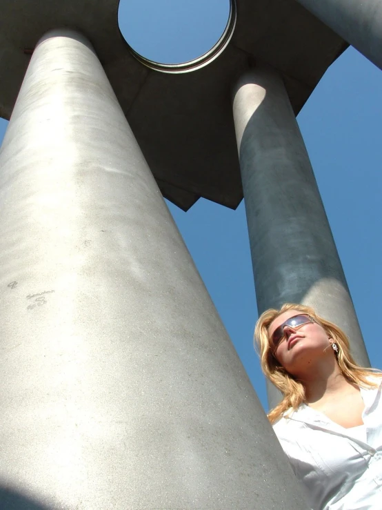 a woman standing in front of a tall tower next to other tall buildings