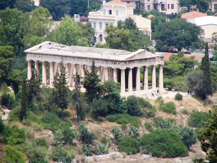 a large building with some white columns and trees around it