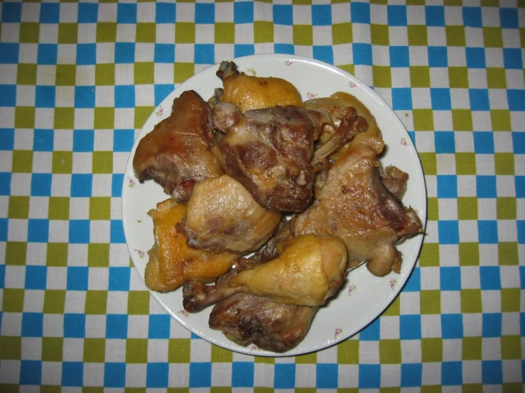 a plate filled with cooked chicken on a table