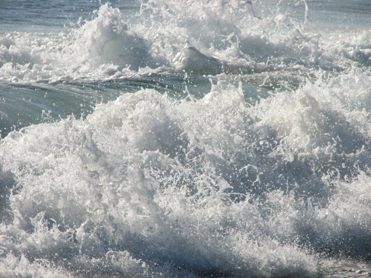 a body of water with waves and a person sitting on a surf board