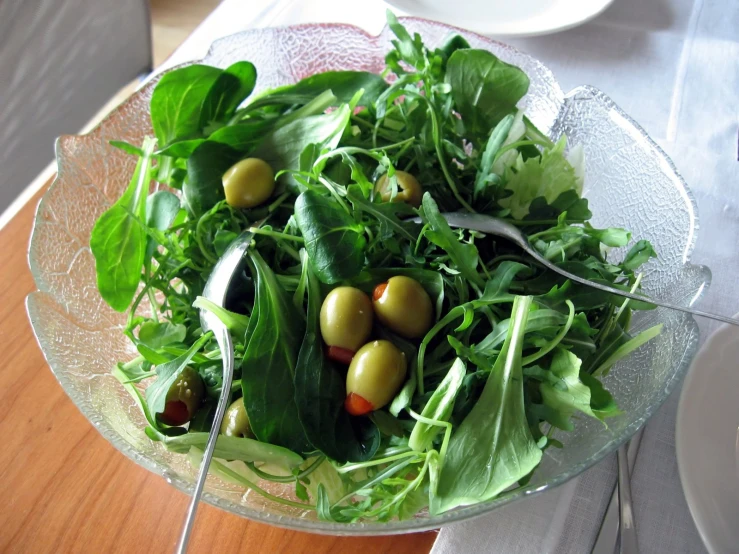 a bowl filled with lettuce and olives