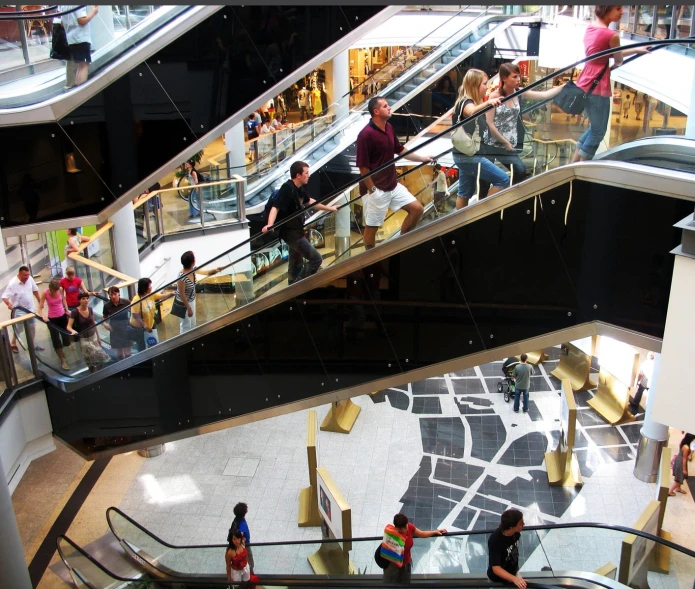 there are people riding escalators inside a mall