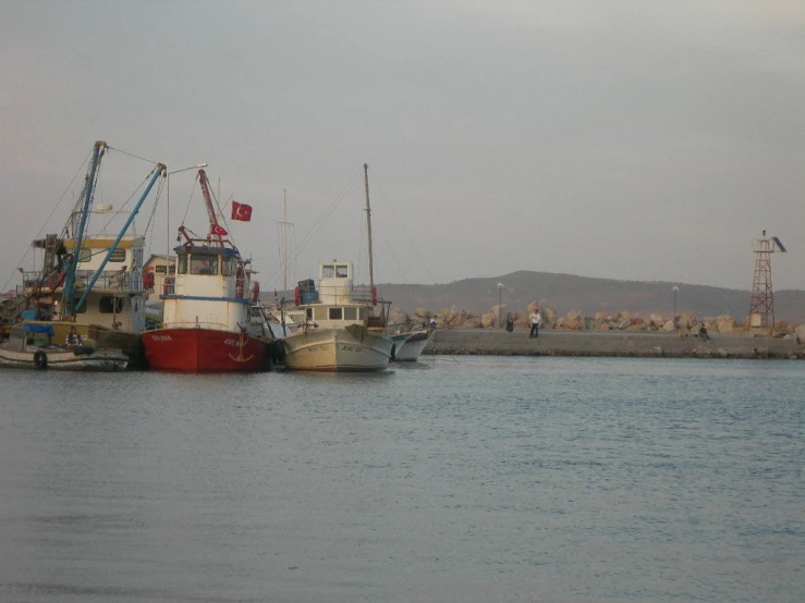 some boats in the water by a pier