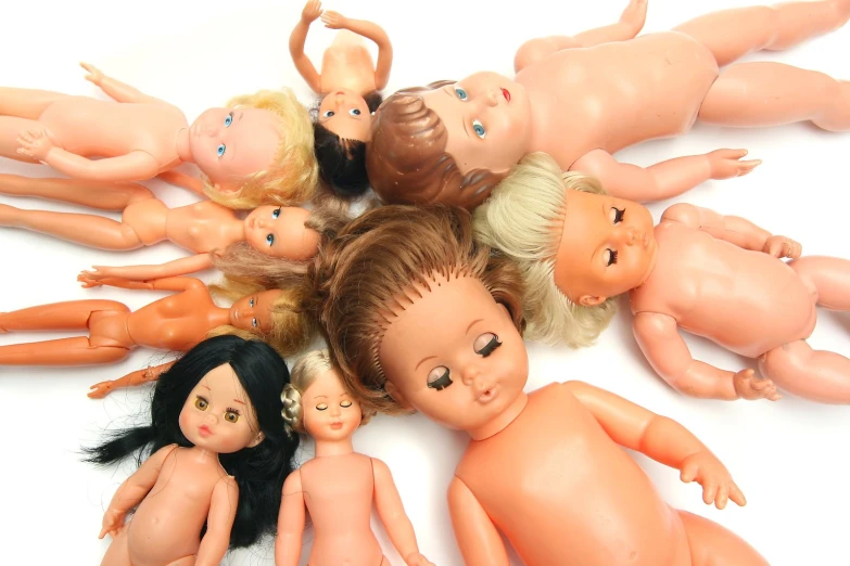 dolls of different ages lie side by side together