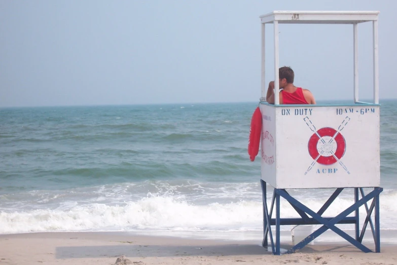 the life guard stands on the edge of the beach