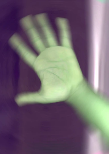 a green hand moving forward with a blurry po