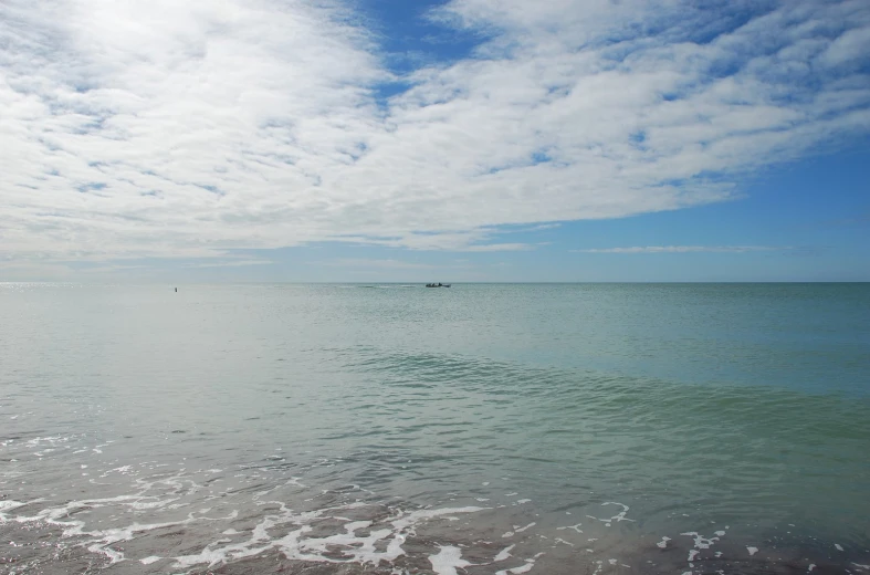 people are out on the beach on their boats