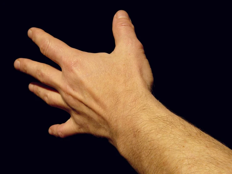 a person with their left hand reaching towards soing