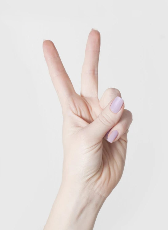 a woman is making the peace sign with her fingers