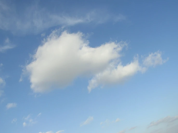 a lone airplane in a very big blue sky