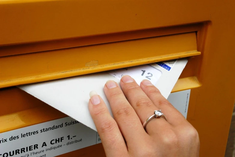 woman placing her wedding ring on top of mail box