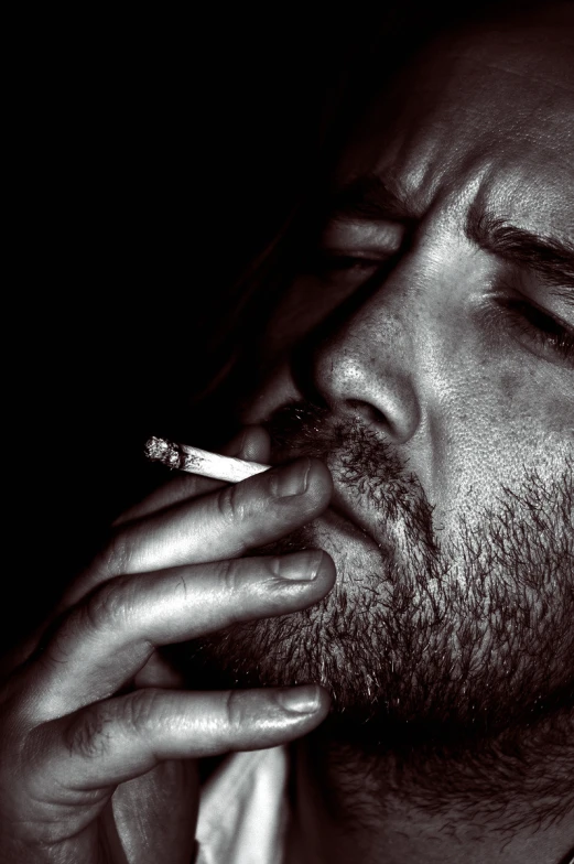 a man smoking a cigarette, in black and white