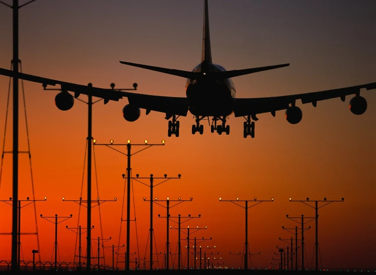 a plane taking off from an airport over power poles